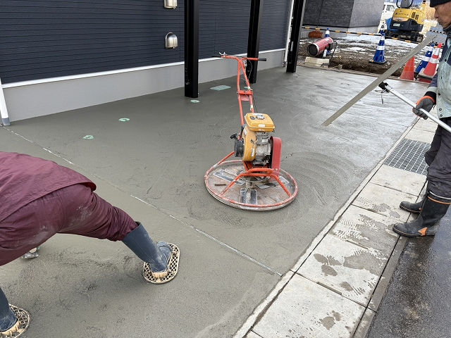 カーポートの下にコンクリート流し整える様子